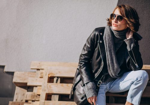 Young woman model in leather jacket outside the street